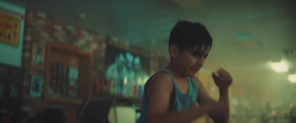 Boy wearing blue tank top practices boxing in gym