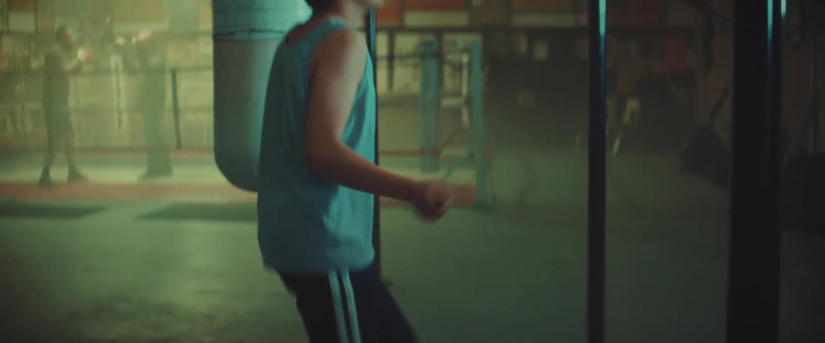 A young kid is jump roping inside of a gym