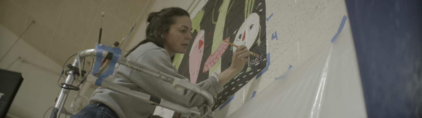 A woman signs her painting