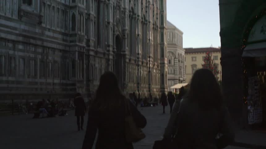 People walk down a busy city street