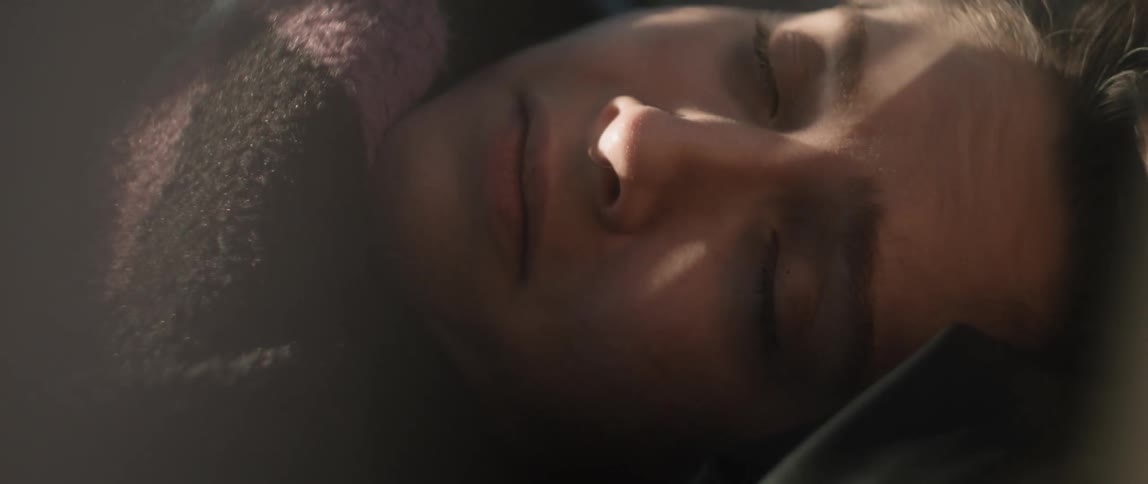 Sleeping woman wakes with sun on her face then rubs eyes and blocks light with her blanket