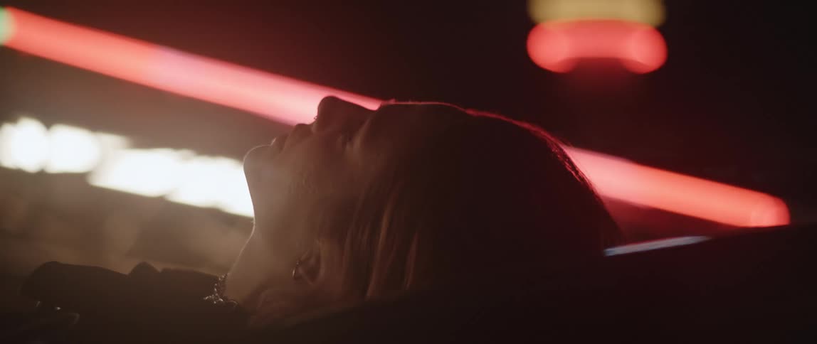 A woman is laying down outside a building with flashing lights
