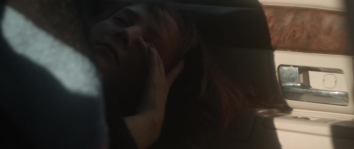 Woman sleeping in car wakes pulling blanket up to block light