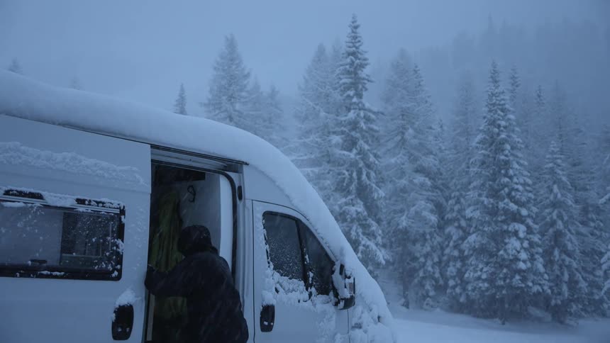 Person running and getting into a parked van during a blizzard