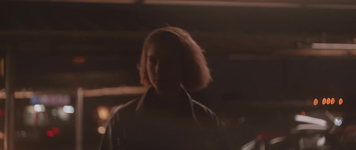 A woman walking around outdoors at night