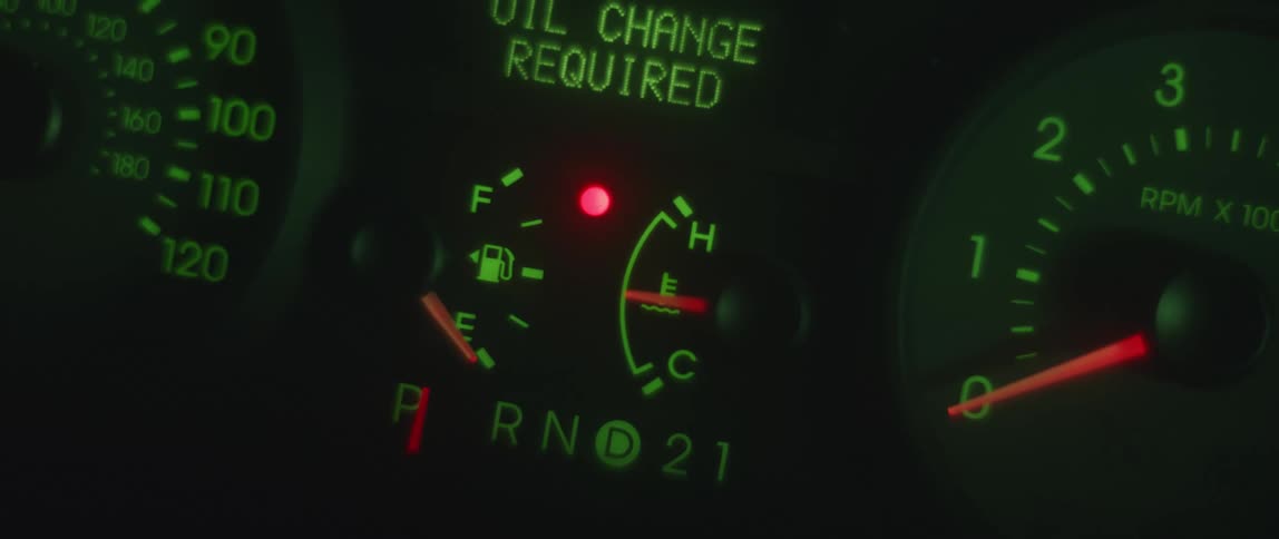 Close up of the dashboard of a car shining green at night