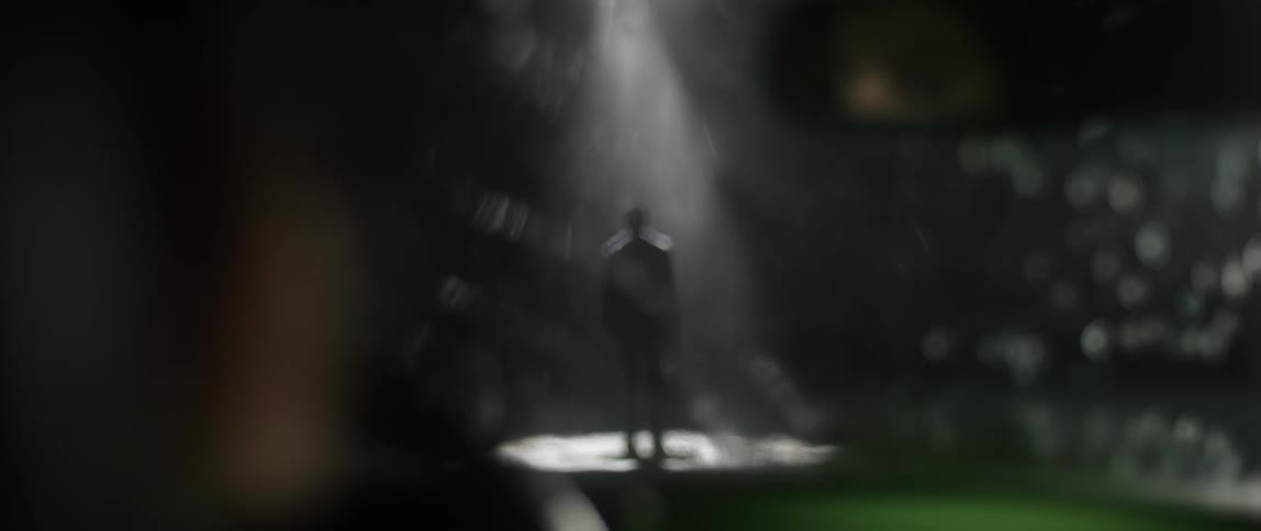 Someone inside an automobile is looking at a man standing under a light in the pouring rain at night through their windshield
