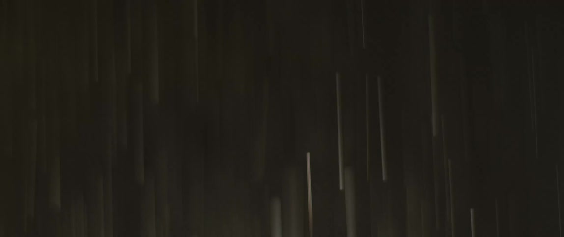Heavy rain falls through air during rainstorm at night