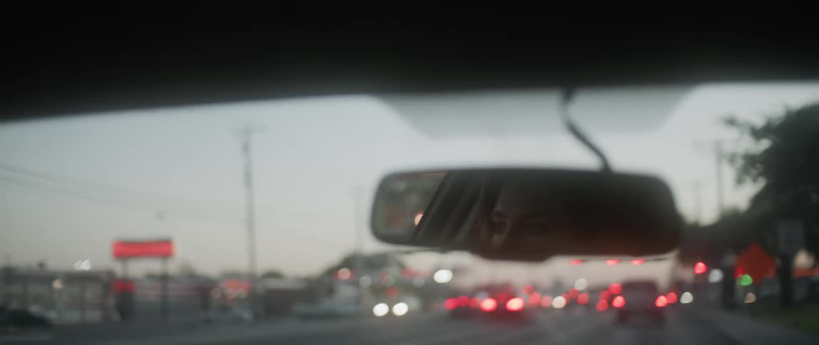 A person is driving their car in town in heavy traffic
