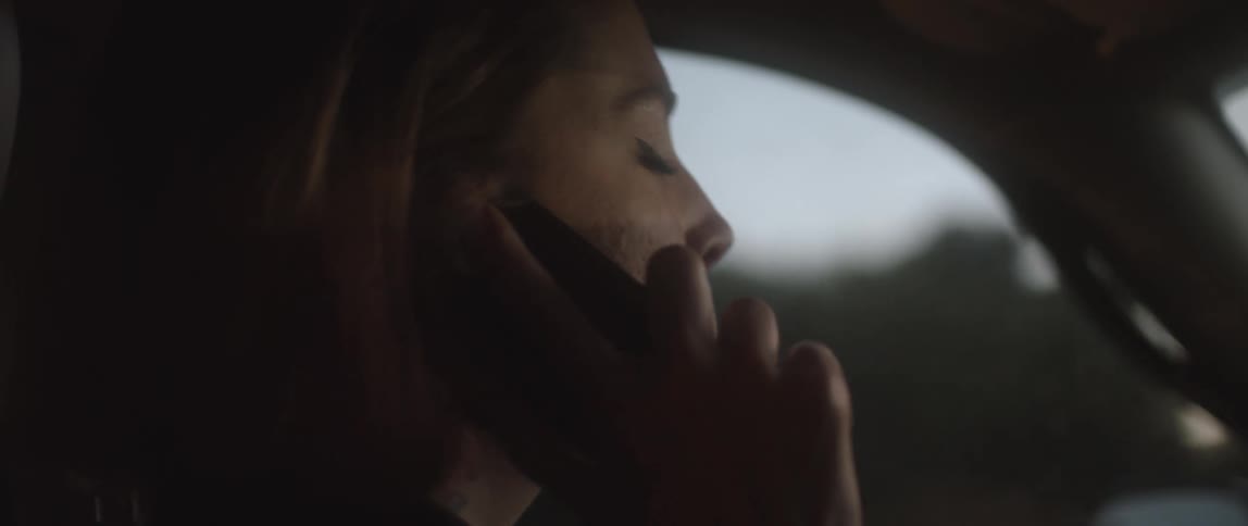 A woman talking on a phone while driving