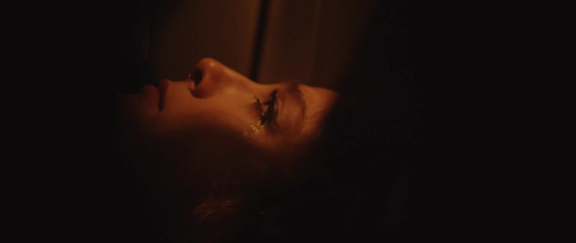 A woman cries while looking at her phone
