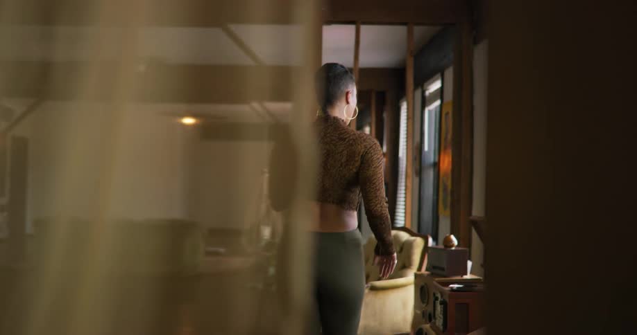 A young black woman is dancing inside of her room in the day time