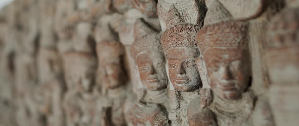 Close up of faces sculpted on the face of a rock wall