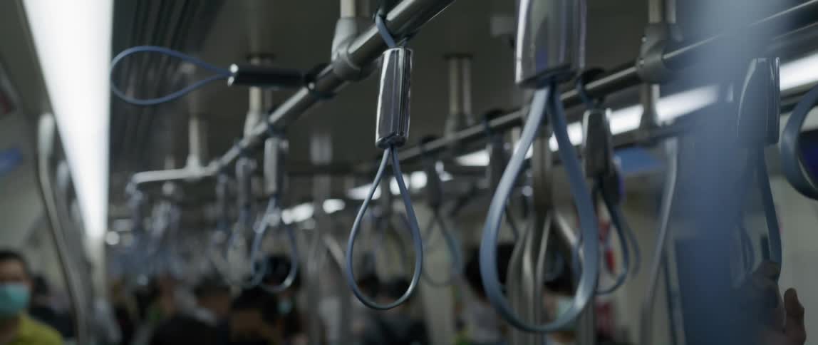 Numerous straps hang downward for passengers to hold while riding on a commuter train