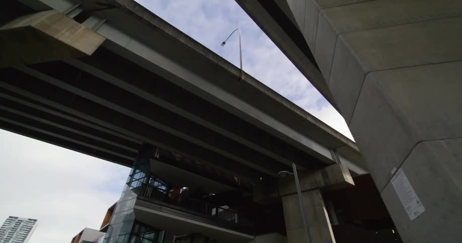 Passing under the highway bridges in the city looking up at morning