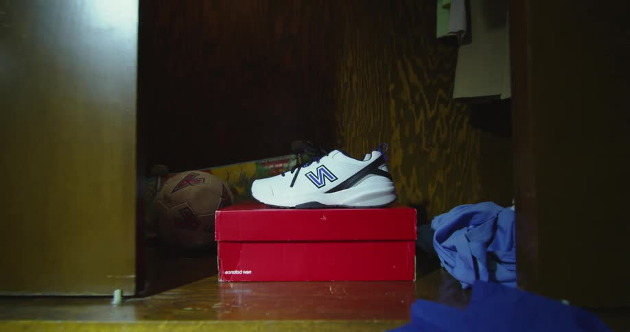 Closet doors close on background white gym shoes on a red box