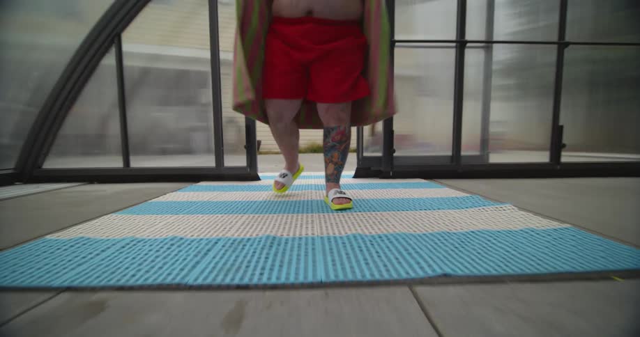 A man walking in to an indoor pool