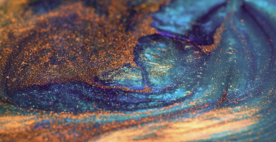 Metallic particles on vivid colorful mixture move as surface spreads and flows
