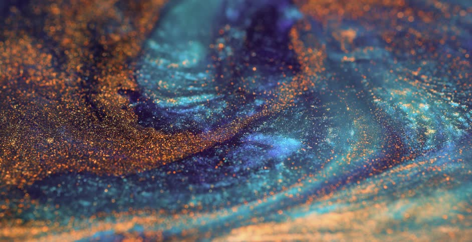 Golden particles floating on the surface of a deep blue liquid