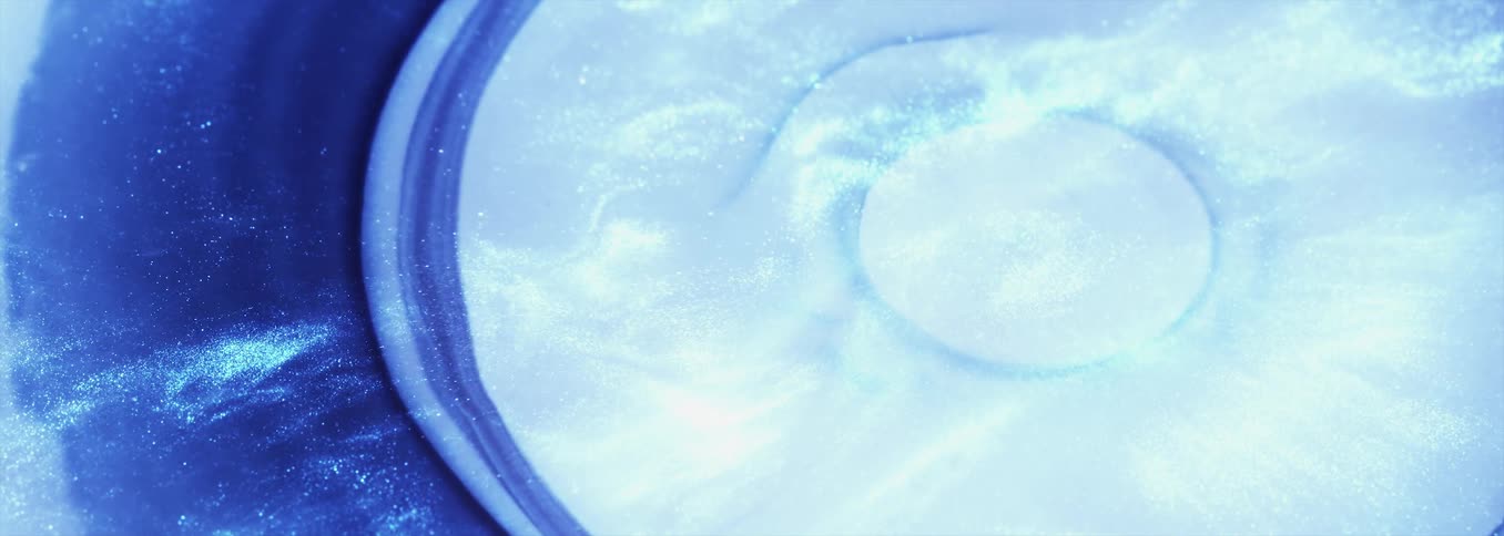 Abstract footage of a droplet of liquid falling in to liquid and spreading