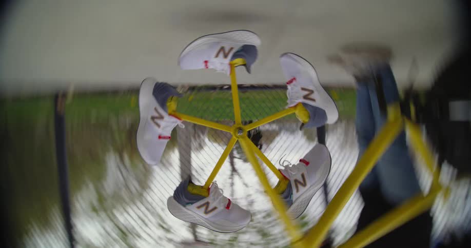 Person stands as sneakerson bars attached to center spin on bicycle wheel