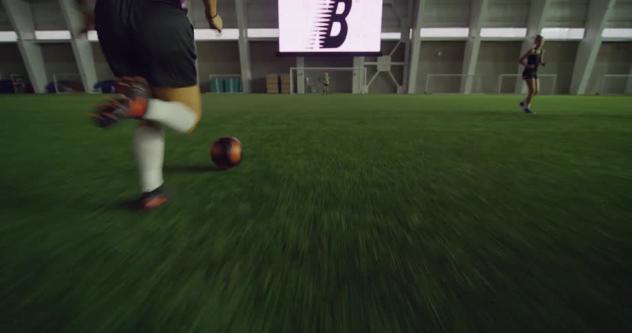 Female soccer players train and play on turf in sports facility