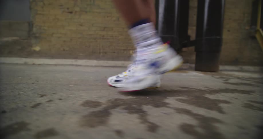 Close up of a man wearing colorful sneakers walking on the city street
