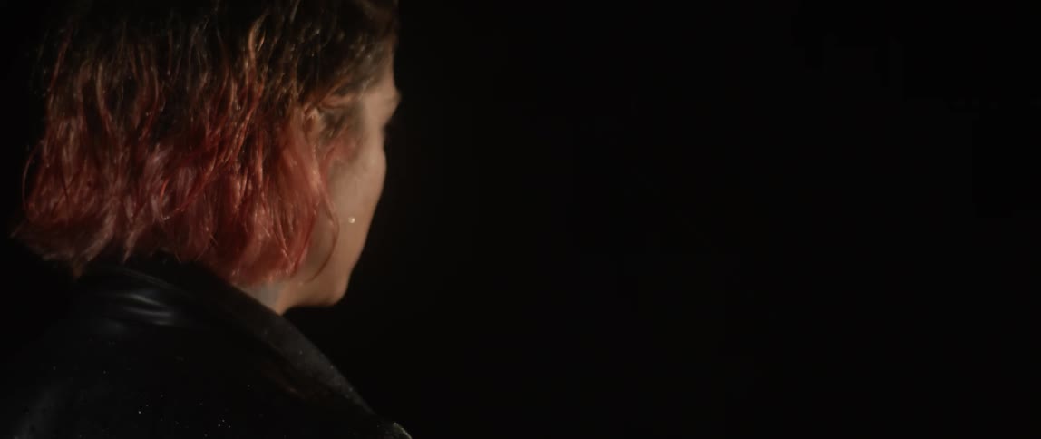 A woman walks out into the rain toward a man