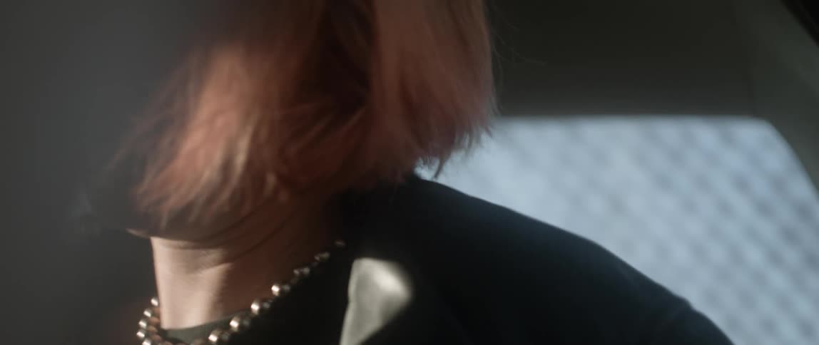 Woman in car puts on leather jacket