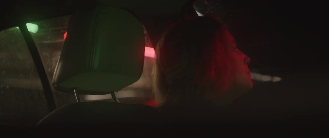 A woman sits in her car