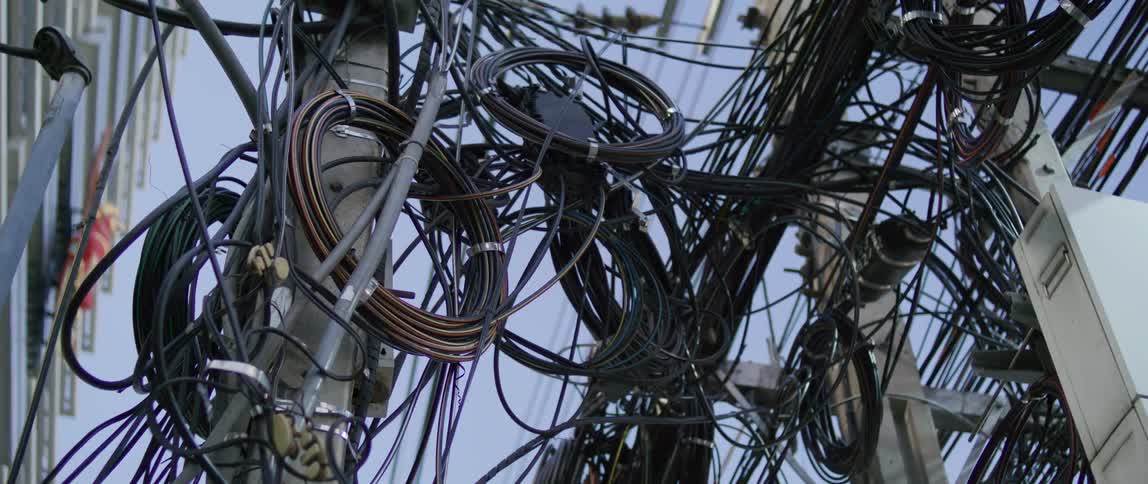 Utility poles in the city densely populated with electrical wires and cables