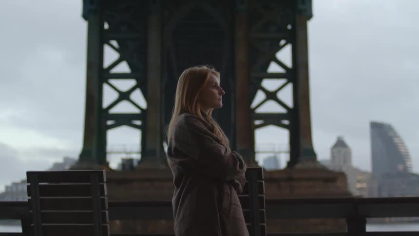 A woman is standing under the bridge