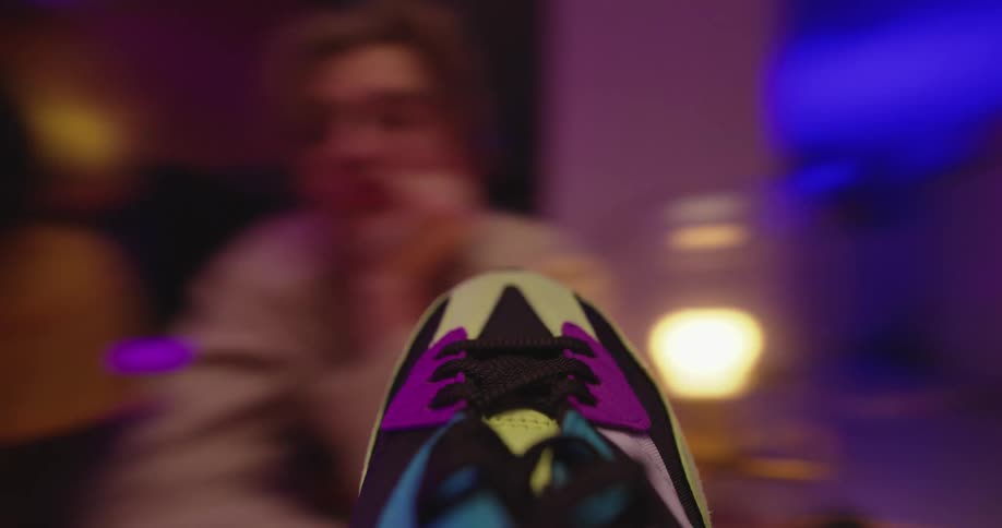 Camera over a sneaker while a group of friends play spin the shoe at a party