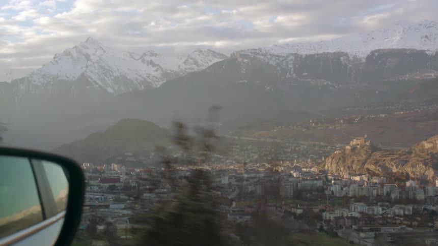 A snow capped mountain as seen from a distant car window