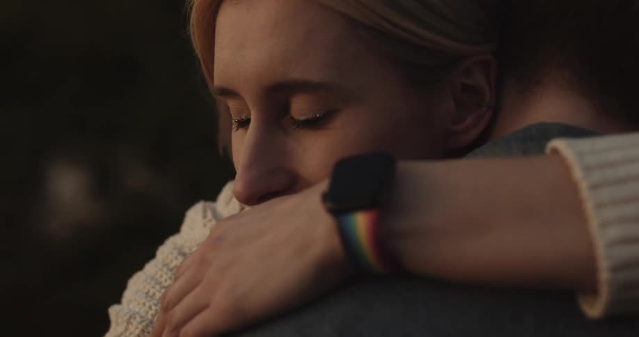 Close up of the face of a happy woman hugging her partner at evening