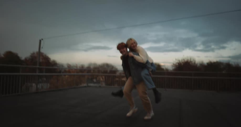 A woman jumps on her partners back for a piggy back ride