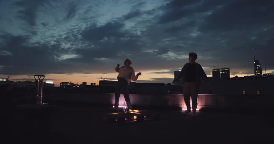 A couple is dancing outside then they embrace