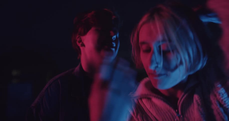 Two people are dancing outside at night time