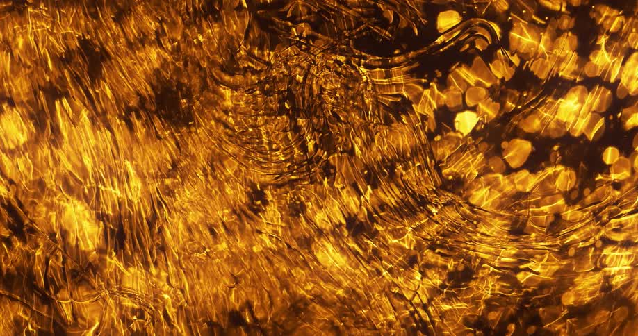 Glowing yellow orbs beneath rippling water