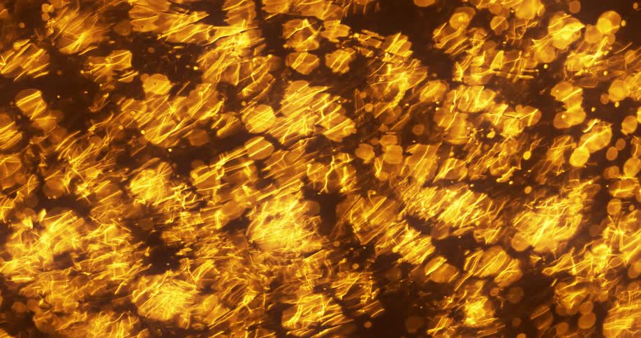 Liquid ripples from left to right over golden orbs