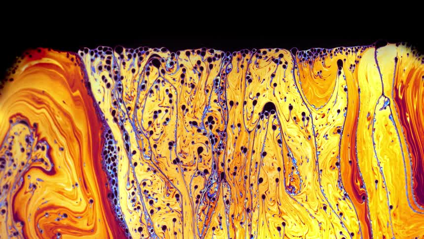 Psychedelic patterns on a swirling colorful yellow liquid