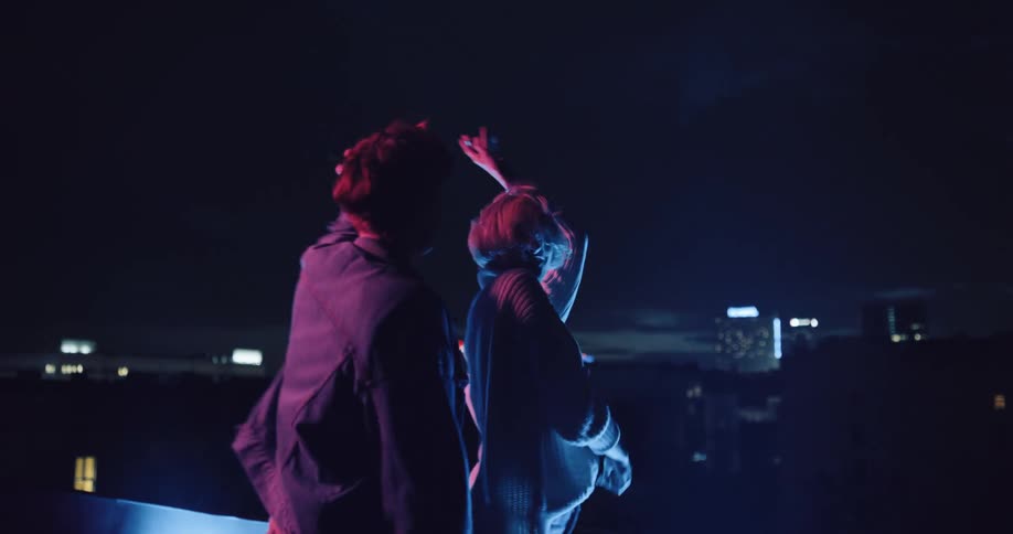 Two women are dancing on the roof