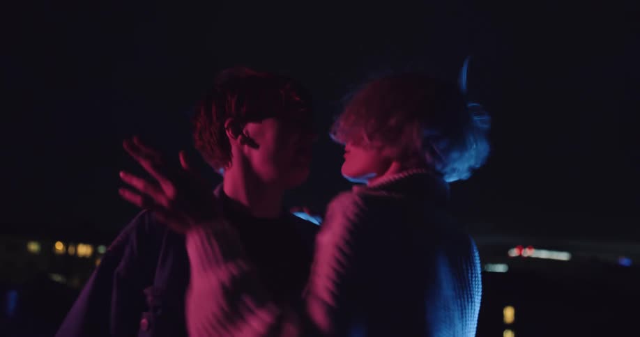Lesbian women dancing and making out on rooftop at night