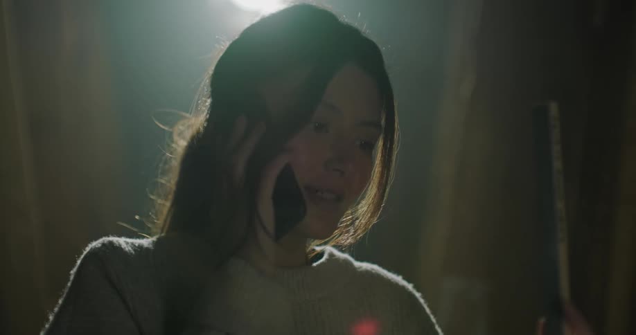 Young female boss talks on phone in her workshop