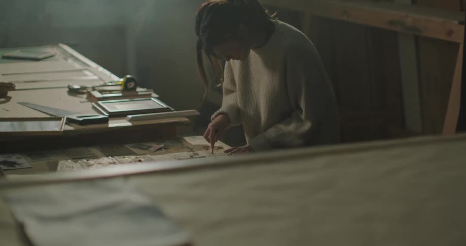 Young artist focused on scrapping the surface of a small piece of wood on her workshop