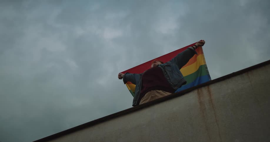 A young white woman is outside and holding a flag