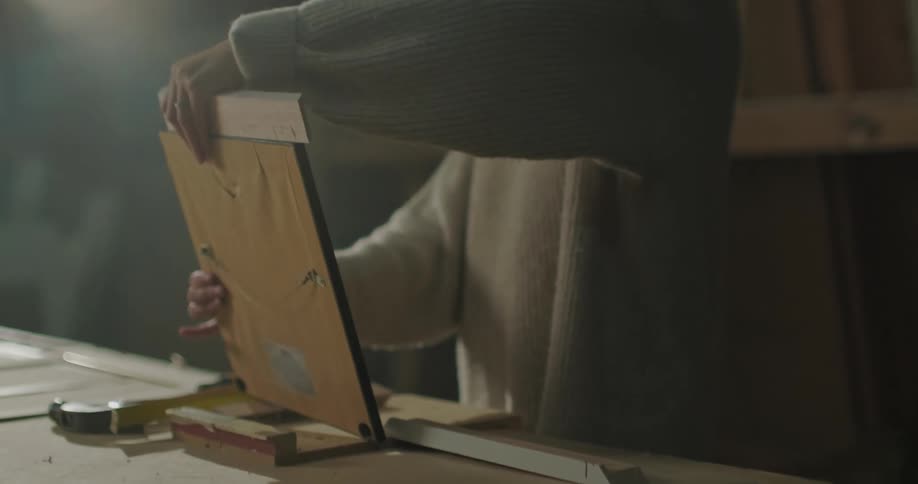 A woman tries to find the right wood for a picture frame