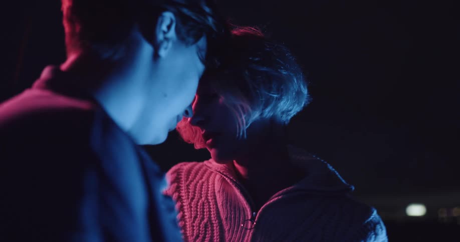 Two women dance and kiss at night