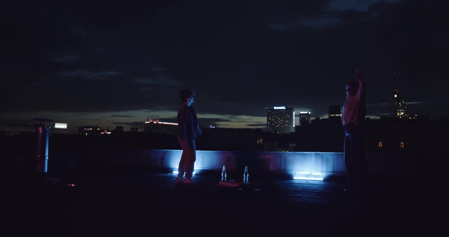 Two people are dancing on top of a rooftop