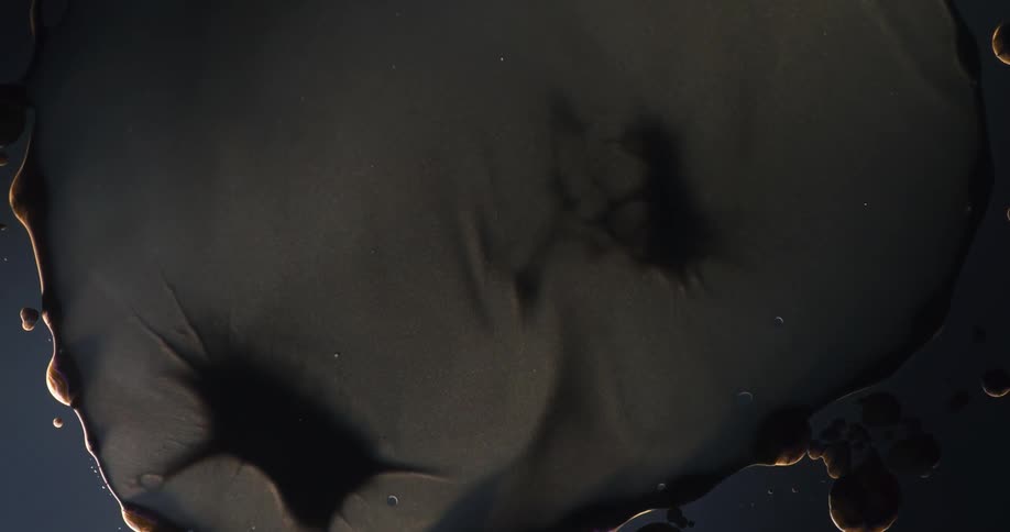Close up of dark floating blobs of flowing liquid oily organic shapes growing and shrinking